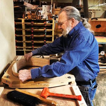 A craftsman placing an inlay logo on an Almansa headstock