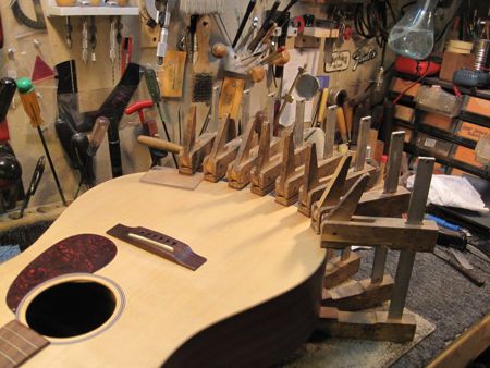 Clamps on the body of a guitar being repaired